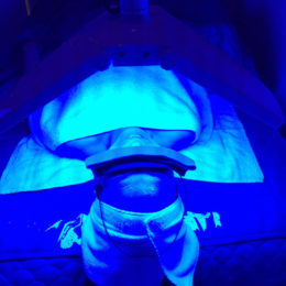 A person is under the uv light in an operating room.