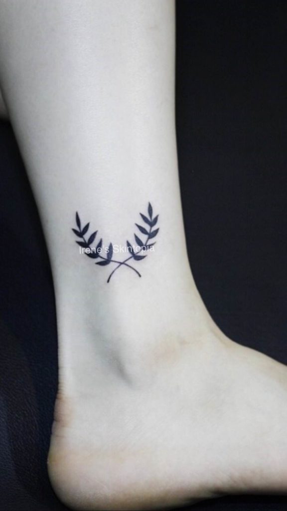 A small tattoo of an olive branch on the ankle.